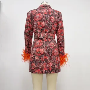 Detailed macro view of the red floral dress back featuring vibrant orange feather cuffs.
