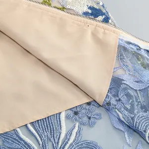 Gros plan sur les broderies délicates, les sequins et la doublure douce d'une robe de soirée.