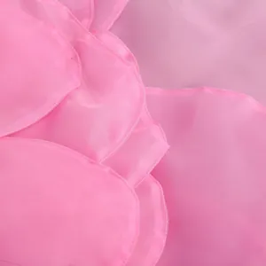 Macro detail of the layered pink fabric petals on an elegant evening party dress.