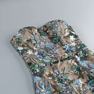 Gros plan sur la broderie florale et les paillettes d'une robe de soirée bustier sans bretelles