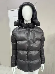 Vista detallada del tejido negro brillante y la capucha de esta chaqueta acolchada para hombre.