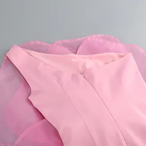 Close-up detail of the back zipper and pink mesh fabric on a one-shoulder party dress.