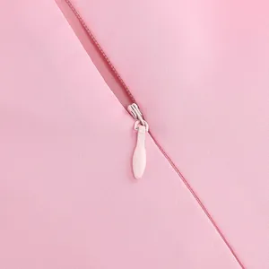 Macro detail shot of a premium invisible zipper on a pink twill fabric party dress