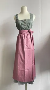 Traditional German Dirndl dress featuring a pink patterned apron and green bodice on mannequin