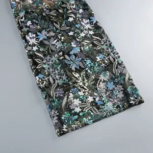 Vue rapprochée détaillée de broderies florales complexes et paillettes sur robe.