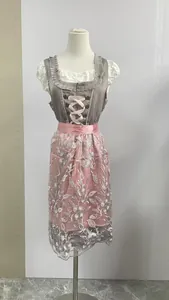 Dettaglio dell'abito Dirndl tedesco rosa e grigio con grembiule in pizzo su manichino