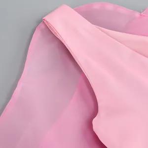 Close-up detail of soft pink mesh layers and shoulder strap of an evening dress