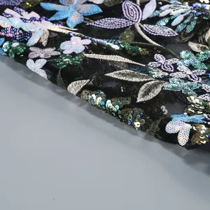 Gros plan de la broderie florale et des sequins colorés sur tissu en maille noire