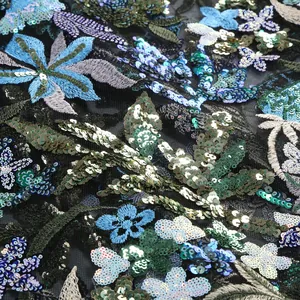 Gros plan d'une broderie florale complexe avec des paillettes sur un tissu en maille
