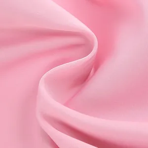 Macro detail of high-quality pink satin fabric with smooth twill texture and sheen