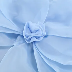 Macro close-up of elegant light blue chiffon rose flower detail on a party dress