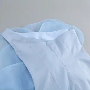 Detailed view of the invisible zipper and layered tulle on light blue party dress