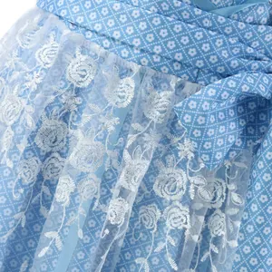 Close-up detail of white rose embroidery on blue floral Oktoberfest dirndl dress