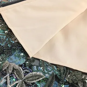 Gros plan de la broderie de fleurs à paillettes et de la doublure d'une robe de soirée chic