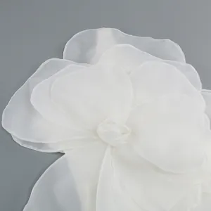 Detailed macro view of white translucent organza flower ornament on luxury evening gown