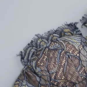 Close-up macro detail of blue and gold eyelash lace patchwork on a sexy fishtail dress.