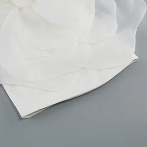 Macro view of white three-dimensional flower petal decorations on a high-end party dress