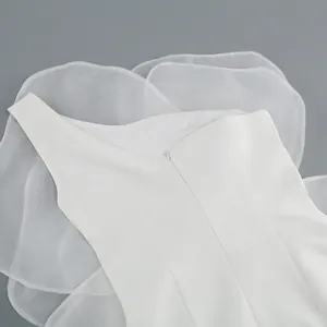 Detail of white one-shoulder cocktail dress with delicate sheer floral petal ruffles