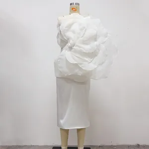 Detailed view of elegant white one-shoulder party dress with a giant 3D fabric flower