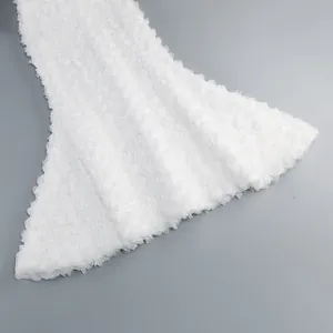 Λεπτομέρεια από λευκό ύφασμα με 3D τριαντάφυλλα στο στρίφωμα του κομψού γοργονέ φορέματος