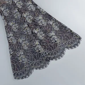 Close-up macro view of the intricate floral lace and eyelash trim on a long fishtail dress hem