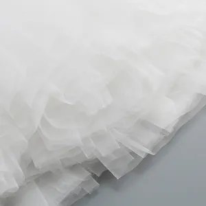 Detailed close-up of soft white multi-layered mesh fabric for a puffy tutu skirt.