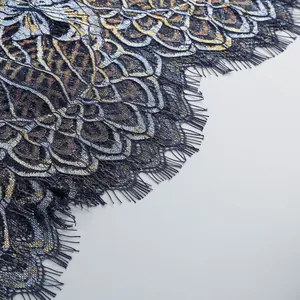 Close-up of intricate navy and gold lace embroidery on a long fishtail dress