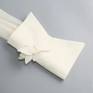 Detailansicht eines weißen französischen Faltenärmels mit eleganter Blattdekoration.