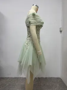 Side view of a light green French lace gown with 3D floral accents and pearl details