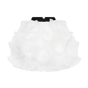 Close-up of a white voluminous ruffled mesh skirt featuring a black contrast waistband design