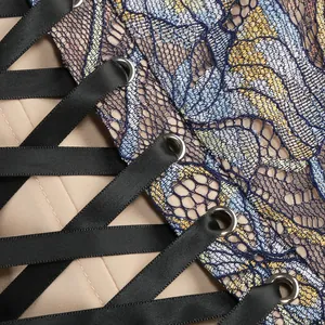 Close-up detail of the elegant black lace-up ribbon and blue floral lace fabric