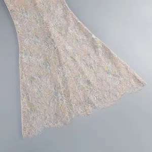 Close-up detail of the intricate pastel floral lace fabric on a mermaid dress hemline