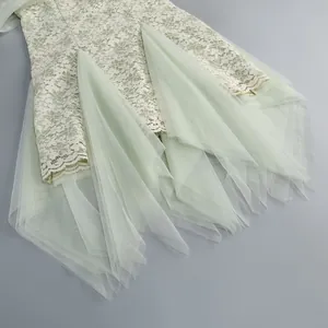 Close-up of a French style lace dress showing layered tulle fabric in soft light green