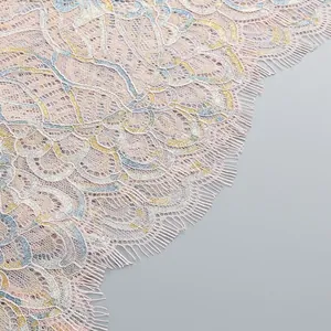 Close-up macro detail of delicate pink floral lace fabric with metallic gold embroidery