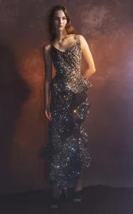 Full-length view of a sparkling strapless sequin midi dress with ruffled hem detail.