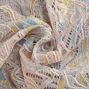 Detailed macro view of pink lace fabric with shimmering gold and blue threads