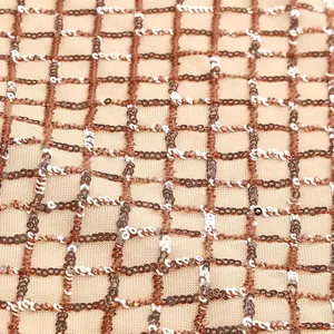 Vista macro che mostra la griglia di paillettes oro rosa e argento su rete champagne