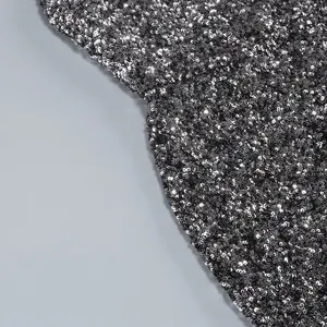 Detailed close-up view of shimmering silver sequins on a cocktail party dress fabric.