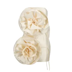 Détail des grandes fleurs en tissu 3D sur une mini robe de soirée bustier de couleur crème