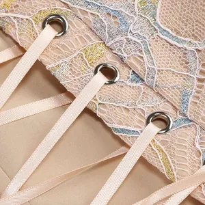 Macro detail of exquisite lace patchwork and silk ribbon lacing on a champagne fishtail dress