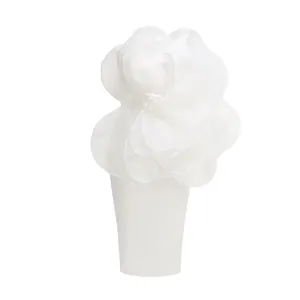 Detail view of a white off-shoulder midi dress with a large 3D organza flower embellishment.