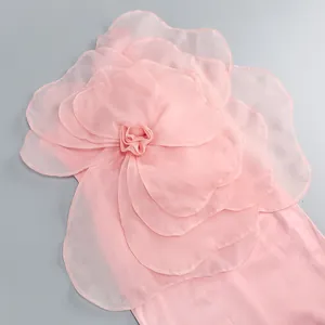 Detailed view of a large 3D fabric flower on a pink elegant party dress for women