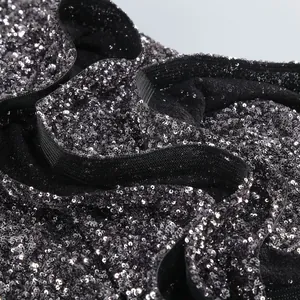 Close-up detail of shimmering silver sequins and elegant ruffled hem on a party dress