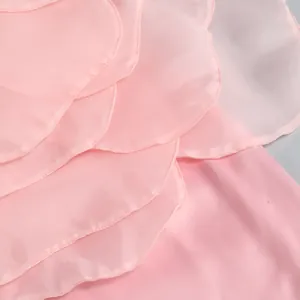 Detail macro view of soft pink layered organza petals on a chic evening party dress