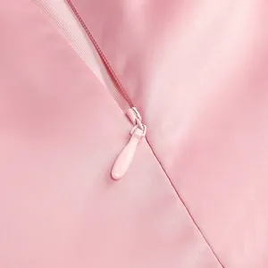 Detailed close-up of a high-quality hidden back zipper on this elegant pink satin dress.