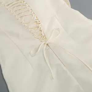 Détail du laçage élégant au dos d'une robe fourreau sexy de couleur crème chic