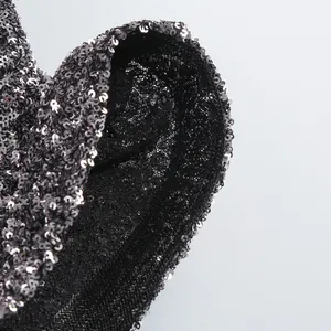Macro view of high-quality shimmering black sequins on party cocktail dress fabric