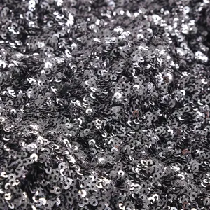 Detailed macro shot of shimmering dark grey metallic round sequins on an elegant party dress