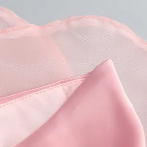 Detailed macro shot of light pink mesh and smooth satin fabric on elegant party dress