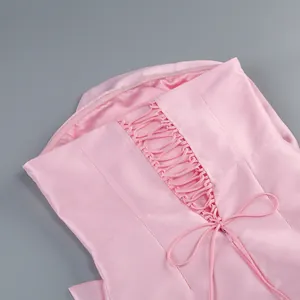 Gros plan du dos d'une robe en satin rose avec laçage élégant et nœud papillon